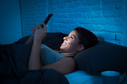 girl-in-bed-using-mobile-phone-late-night-happy-relaxed